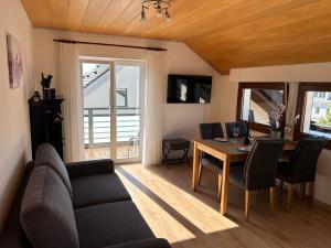 a living room with a couch and a table with chairs at Ferienwohnung Stefanie in Hagnau