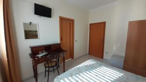 a bedroom with a desk and a bed and a desk with a computer at B&B Le Ginestre in Foria