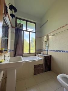 a bathroom with a tub and a sink and a window at Muangkham in Chiang Rai +44 photos