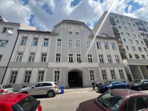 a large building with cars parked in a parking lot at Lilly apartments in Bratislava