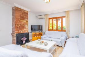 a living room with white furniture and a fireplace at Ca Na Clara - Villa Pascual in Port de Pollensa