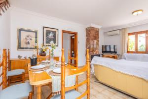 a bedroom with a bed and a dining room with a table at Ca Na Clara - Villa Pascual in Port de Pollensa