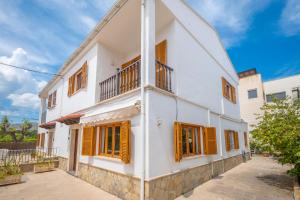 a white house with yellow shutters on it at Ca Na Clara - Villa Pascual in Port de Pollensa