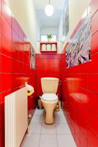 a red bathroom with a toilet and red tiles at Altstadtzimmer im Herzen des historischen Wiens in Vienna