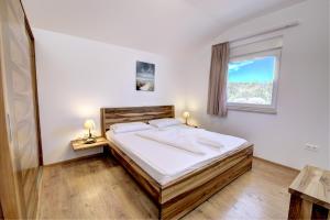a bedroom with a bed with white sheets and a window at Cool Šilo Appartement Resort in Šilo +37 photos