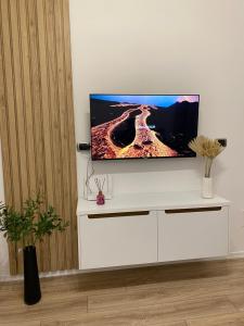 a flat screen tv sitting on top of a white entertainment center at Riara Home in Vlorë