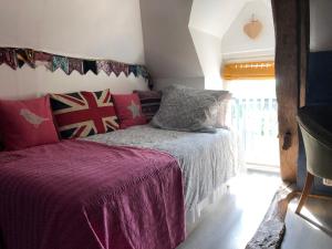 Bramble cottage في Saint-Didier-en-Donjon: غرفة نوم بسرير وبطانية ارجوانية