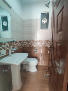 a bathroom with a toilet and a sink at Airport Transit Lodge in Islamabad +27 photos