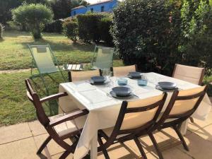 a white table with four chairs around it at La maison aux galets in Talmont
