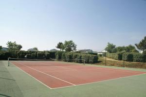 a tennis court with a net on top of it at La maison aux galets in Talmont