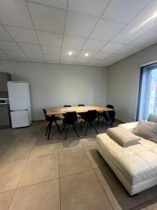 una habitación con una mesa y sillas y un sofá en Modern apartment, en Maaseik