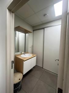un baño con lavabo y espejo en Modern apartment, en Maaseik 6 fotos más
