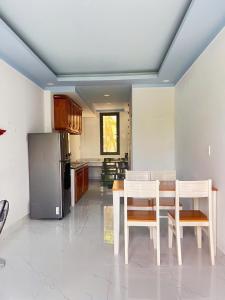 Una cocina con mesa y sillas y un refrigerador. en Green Bungalow Phú Quốc, en Phu Quoc