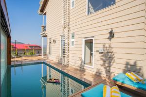a house with a swimming pool next to a house at ELIVAAS privé The Royce Orchid 4 BHK Hilltop Villa With Jacuzzi, Steam Room, Private Pool & Hill Views in Kasauli