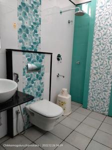 a bathroom with a toilet and a sink and a shower at Townhouse Nisarga in Chikmagalūr