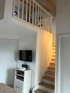 a staircase leading up to a room with a television at La maison aux galets in Talmont +1 photo