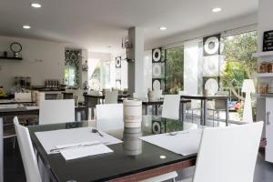 a dining room with a table and white chairs at Villa Liliana in Cervia
