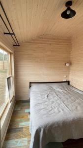 a bedroom with a bed in a wooden room at Экохаус Бурабай 2 in Borovoye