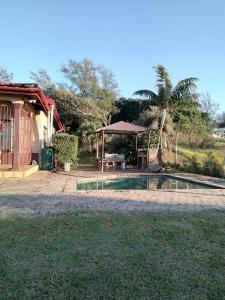 a house with a pool and a table and a tent at Marinda's in Hibberdene