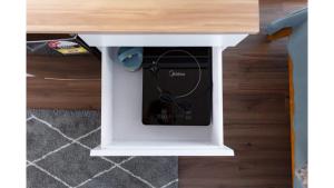 a white table with a tv inside of it at Muddy Hill Moments by Tiny Away in Arrowtown