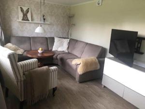 a living room with a couch and a tv at Family House Near Beach With Garden in Sarup