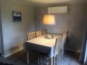 a dining room table with chairs and a lamp at Family House Near Beach With Garden in Sarup +15 photos