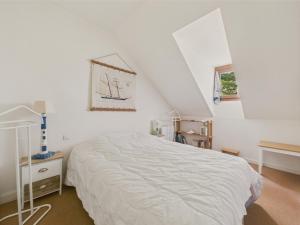 a white bedroom with a bed and a window at 400m de la plage, jardin, maison pour 5 in Kermoisan