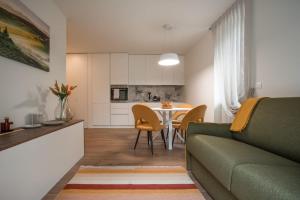 a living room with a green couch and a table at Anise Suites in Lovero Valtellino