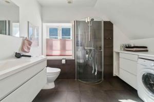 un bagno bianco con doccia e WC di Lovely House In Svanneke On Bornholm a Svaneke Altre 27 foto