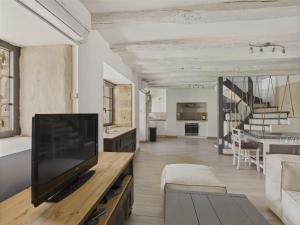 ein Wohnzimmer mit einem Flachbildfernseher auf einem Tisch in der Unterkunft Maison pour 5 avec cour extérieure dans le centre in Saint-Léon-sur-Vézère