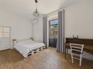 ein Schlafzimmer mit einem Bett, einem Schreibtisch und einem Klavier in der Unterkunft Maison pour 5 avec cour extérieure dans le centre in Saint-Léon-sur-Vézère