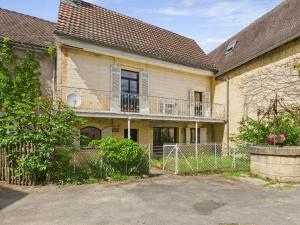 ein altes Haus mit Balkon und Zaun in der Unterkunft Maison pour 5 avec cour extérieure dans le centre in Saint-Léon-sur-Vézère