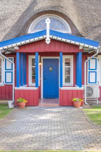 eine rot-blaue Kapelle mit einem Kreuz darauf in der Unterkunft Vila Pervalka in Pervalka