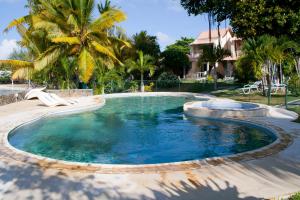 a swimming pool in a yard with palm trees at Villas Banyan in Grand Gaube