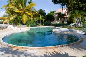 una piscina en un patio con palmeras en Villas Banyan, en Grand Gaube