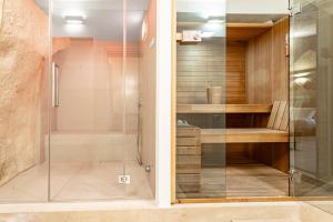 una ducha con puerta de cristal en un baño en GuestHost - White Stones Rooms, en Matera