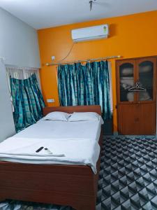 Cama en habitación con pared de color naranja en Sidds Hospitality Inn, en kolkata 40 fotos más