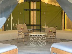 a room with chairs and a table and a tent at Canopy Villa Glamping Park in Kampong Sum Sum