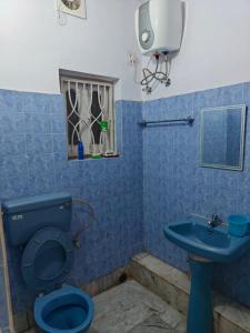 a bathroom with a blue toilet and a sink at Sidds Hospitality Inn in kolkata +40 photos