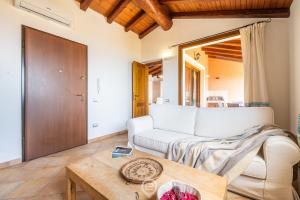 a living room with a white couch and a table at Cliffside Blue in Costa Rei