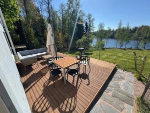 a wooden deck with a table and chairs and an umbrella at Lakeview apartment, Espoo in Espoo