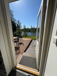 an open door to a patio with a table and a view at Lakeview apartment, Espoo in Espoo