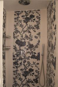 a bathroom with a black and white patterned wall at Domo sa prama in Cala Liberotto