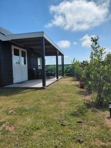 a small house with a porch and a patio at Wildzicht Cosy Cabins in 't Zand