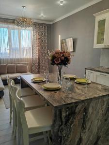 a living room with a table with plates and flowers on it at ЖК Madina in Petropavlovsk