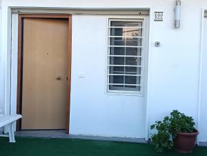 a white house with a door and a window at Deliziosa House - Schiavonea in Schiavonea