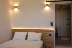 a bed with two pillows and two lights above it at Cuarenta tinos in Agios Fokas