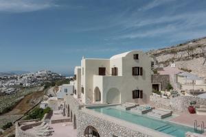 a villa with a swimming pool on a cliff at Zatrikion Santorini Villas in Pirgos