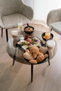 a glass coffee table with food and drinks on it at Boutiquehotel Reuter GmbH in Hattingen