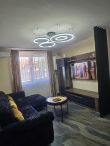 a living room with a couch and a flat screen tv at CityVibe Apartament in Luduş